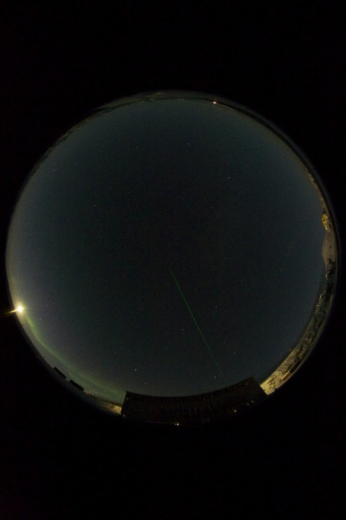 All sky image of the sky in Ny-Ålesund together with the marinelab and the laser beam from the Alfred Wegner Institute observatory (photo: Geir Johnsen)